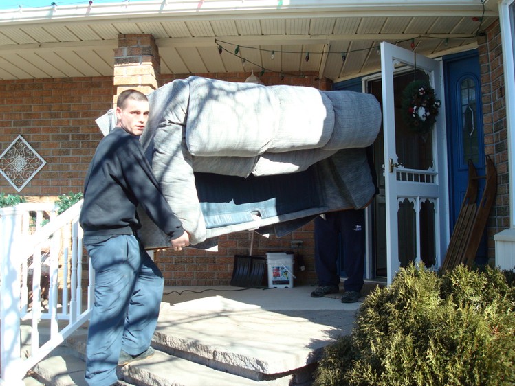 Movers carrying furniture out of a house