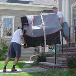 Movers carefully moving a piano